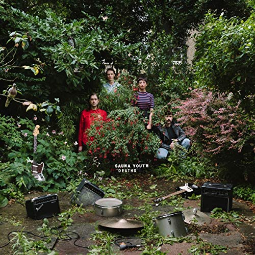 Band Sauna Youth in a lush garden with musical instruments.