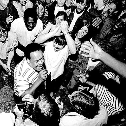 Black and white photo of a crowded, energetic music festival scene.