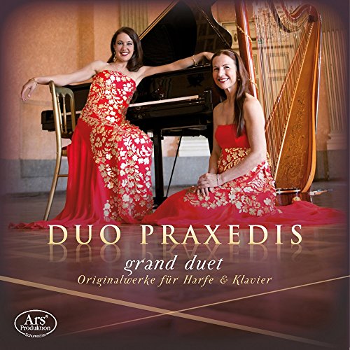 Two women with a harp and piano in a formal setting.