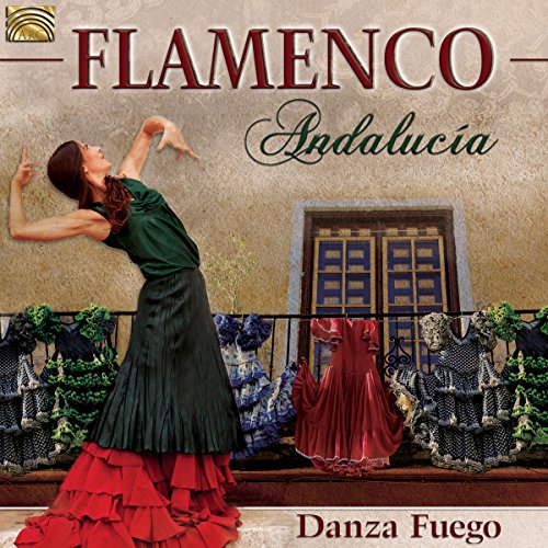 Flamenco dancer in red and green dress before an Andalusian building.