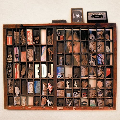 Wooden tray display with various small objects and the letters "EDJ".