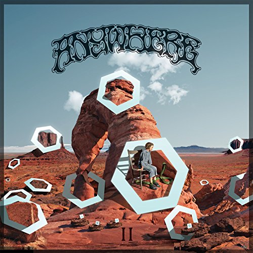 Album cover: desert landscape with rock formations and a seated figure.