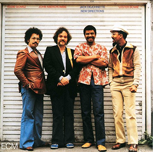 Album cover featuring four musicians standing in front of a metal door.