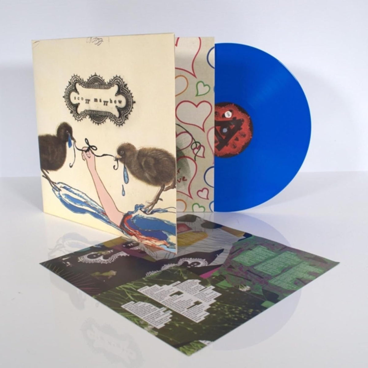 Vinyl record of “Scott Matthew” with illustrated cover and blue disc.
