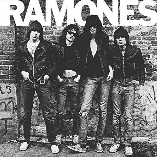 Black and white photo of The Ramones band members posing against a brick wall.