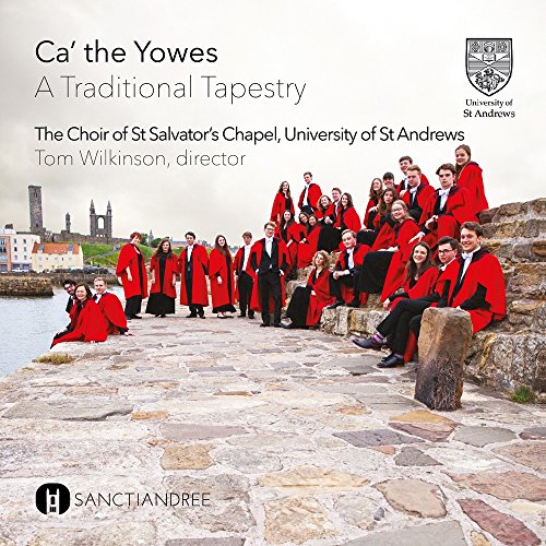 Choir in red robes posed on stone steps overlooking a coastal town.