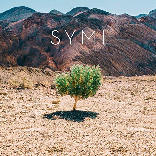 Desert landscape with a small tree and the text "SYML" above mountains.