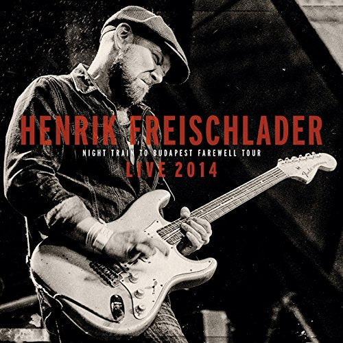 Henrik Freischlader playing a light-colored electric guitar on stage.
