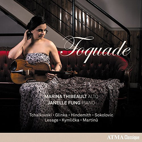 Woman with viola seated on a red couch, album cover art.