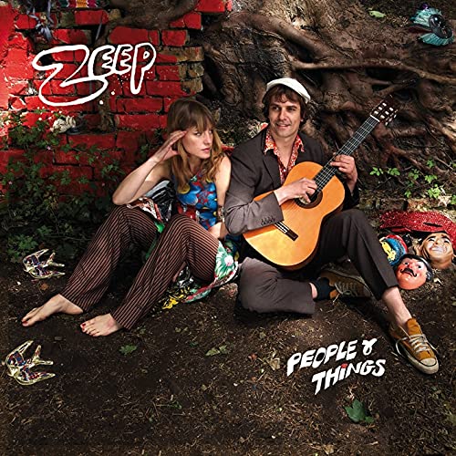 CD cover featuring a man with a guitar and a woman, surrounded by dolls.