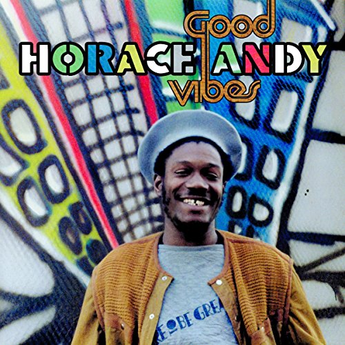 Horace Andy wearing a cap and jacket against a colorful graffiti background.