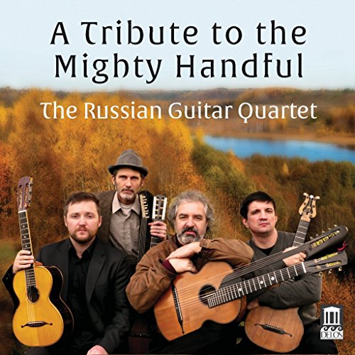 Four men with guitars stand outdoors in front of autumn trees.