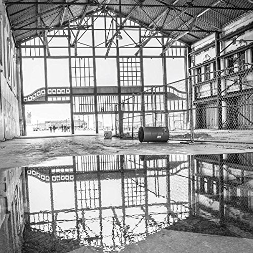 Black and white photo of a large, empty industrial building interior.