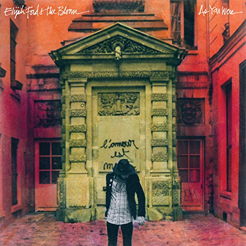 CD cover: building facade with graffiti and a person in a hat.