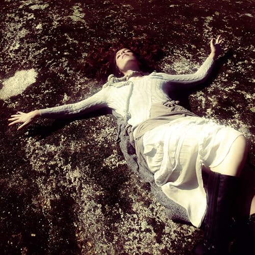 Woman with curly hair lying on a textured, dark surface.