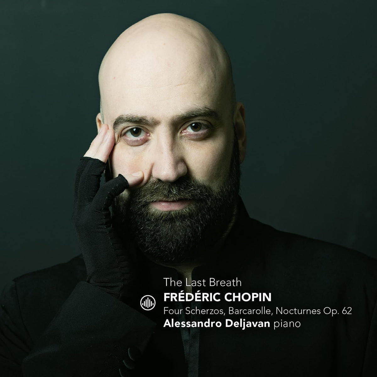 Close-up portrait of bald pianist Alessandro Deljavan with a dark beard.