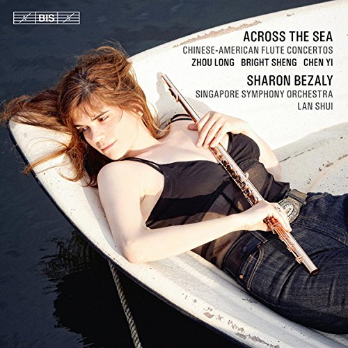 Woman with flute lying in a small white boat on dark water.