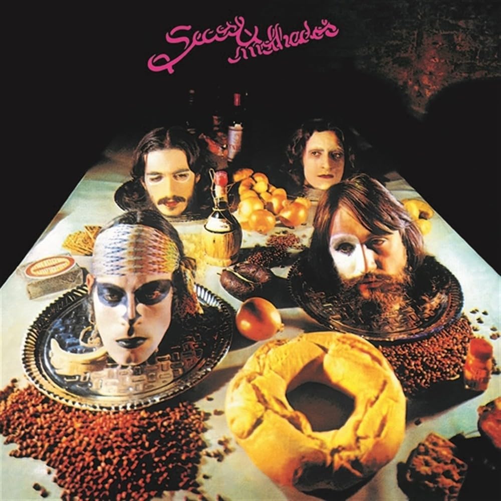 Album cover for "Secos & Molhados" featuring four figures and food.