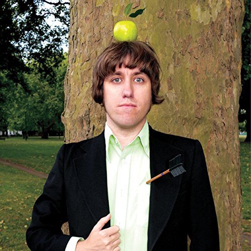 Man in suit with apple near tree, album cover art.