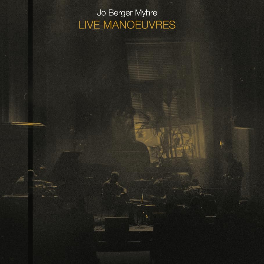 CD cover: dimly lit musicians performing on a dark stage.