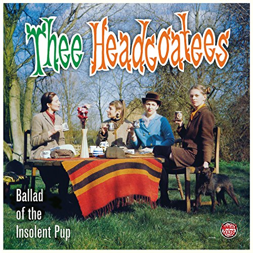 Four women at a picnic table with a small dog, album cover.