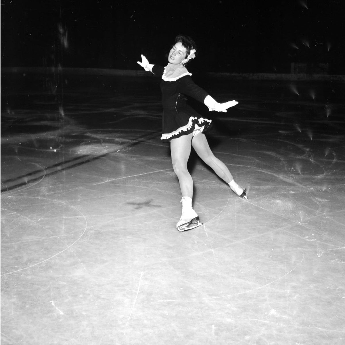 Black and white photo of a figure skater on ice.