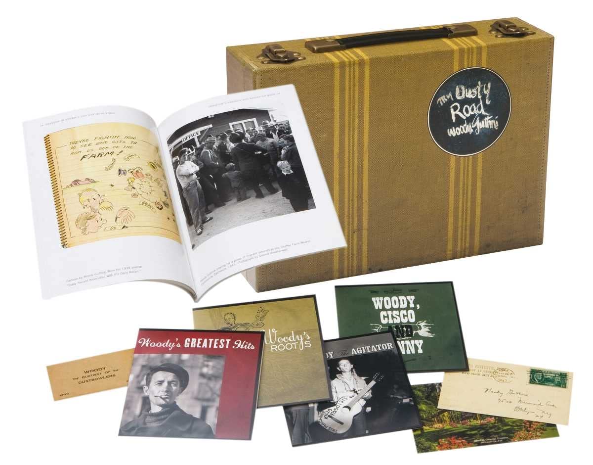 Woody Guthrie CD packaging with photos, postcards, and a worn guitar case.
