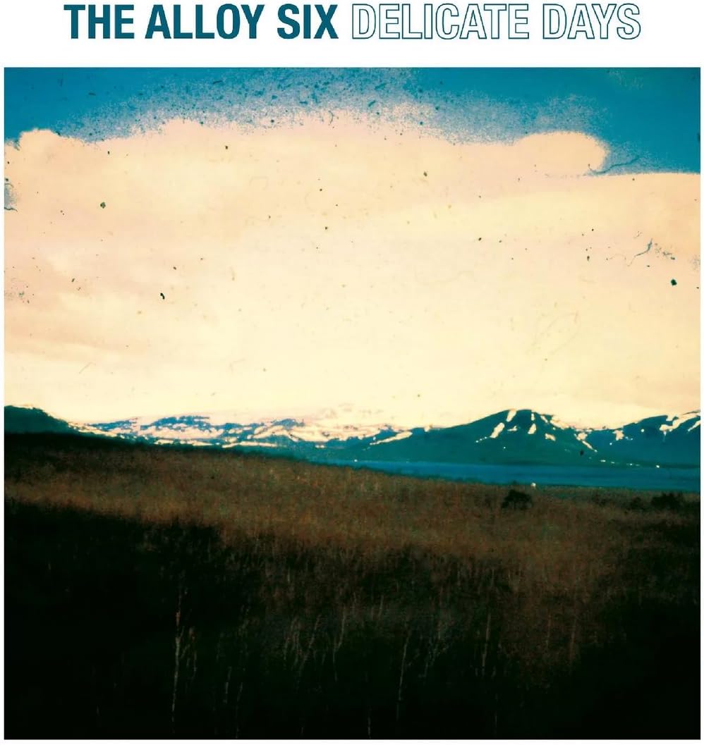 Album cover for "Delicate Days" featuring snowy mountains and a pale sky.