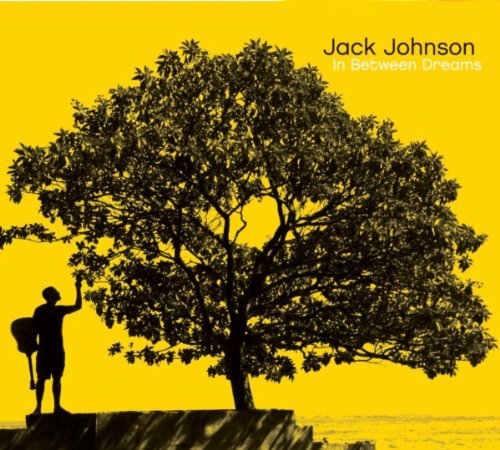 Silhouette of a person with a guitar standing by a tree against yellow background.
