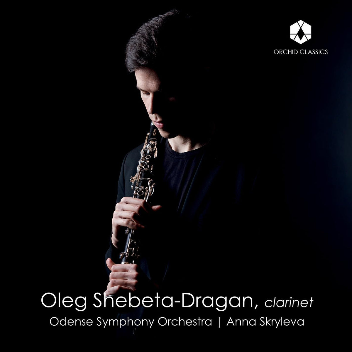 Clarinetist Oleg Shebeta-Dragan in dark clothing against a black background.