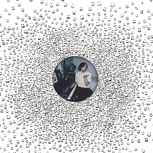 CD cover with a portrait in a circular opening, speckled background.
