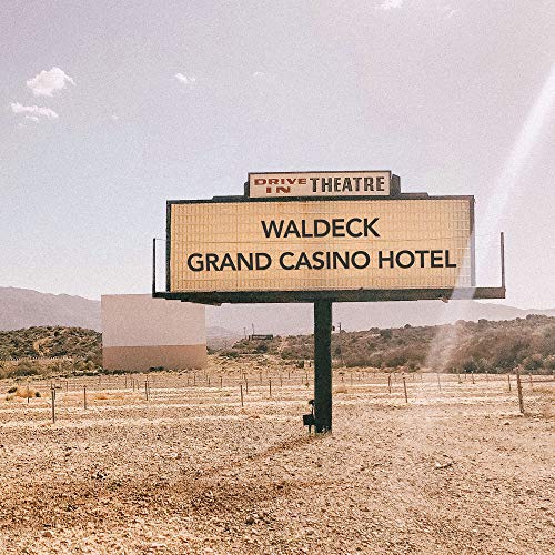 Drive-in theatre sign reading "Waldeck Grand Casino Hotel" in a desert landscape.