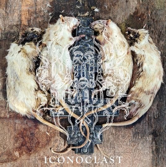 Rats surround an ornate, dark cross on a weathered wooden surface.