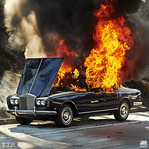 Burning dark blue car with open hood, smoke and flames rising.