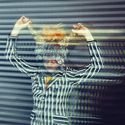 Blurred image of person with jewelry raised above head.