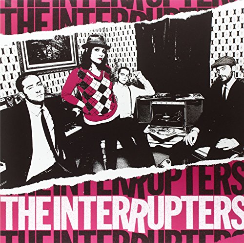 The Interrupters band members posing in a room with pink and black graphic borders.