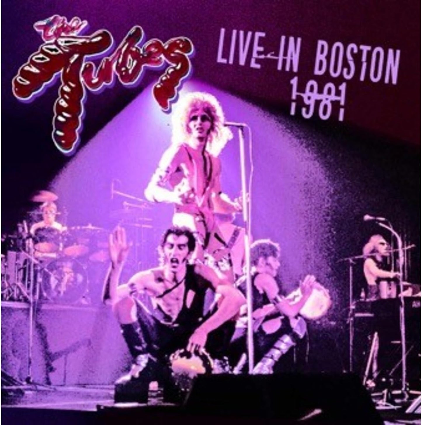 The Tubes performing live on stage under purple stage lighting.