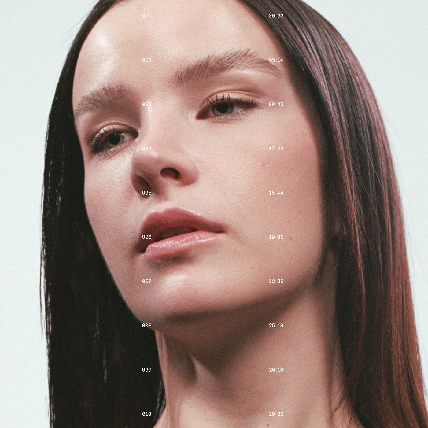 Close-up portrait of a woman with timecode numbers overlaid on her face.