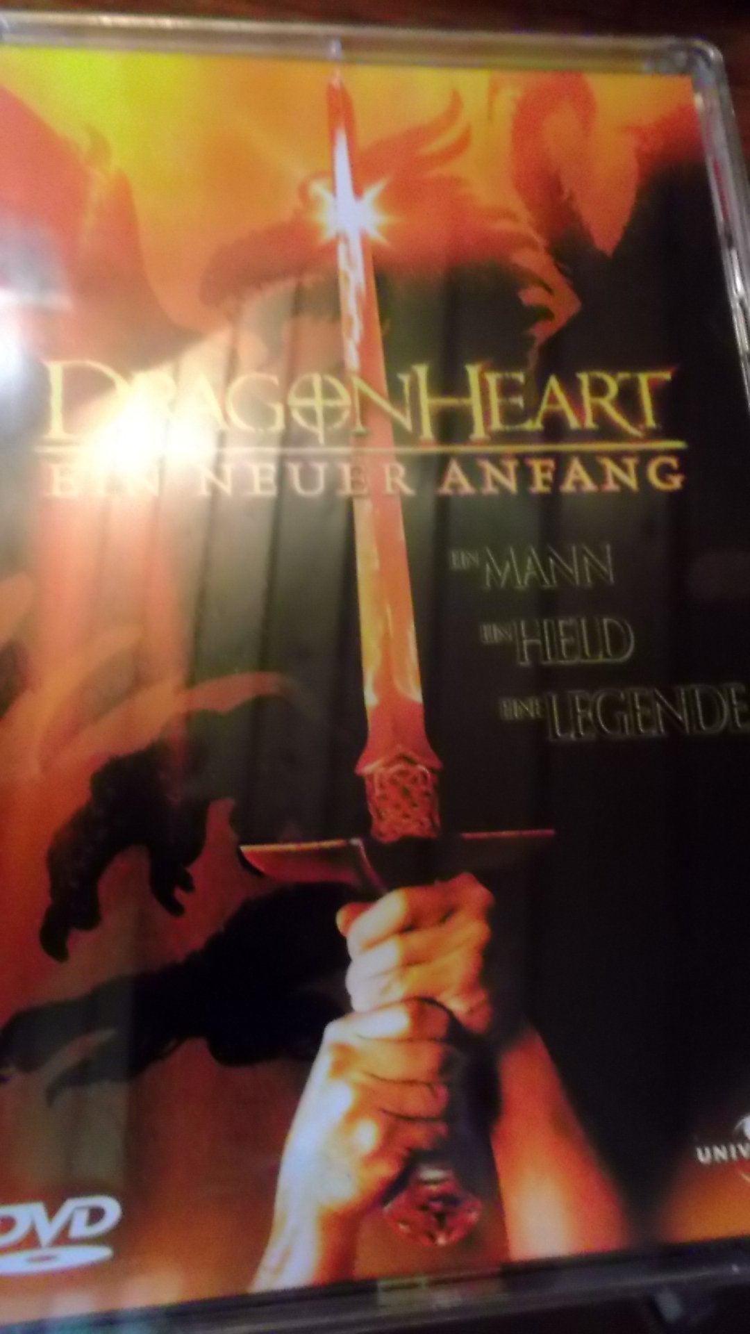 DVD cover art showing hands holding a glowing sword against a fiery dragon background.