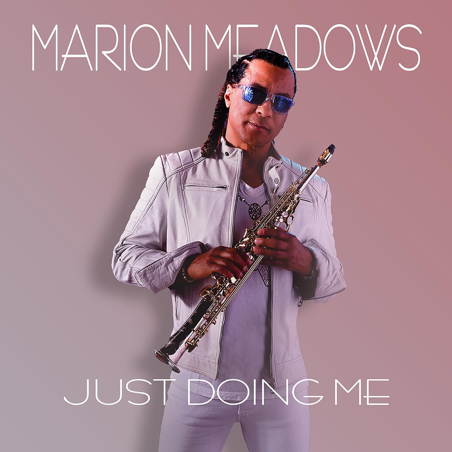 Marion Meadows wearing sunglasses and a white jacket, holding a saxophone against pink background.