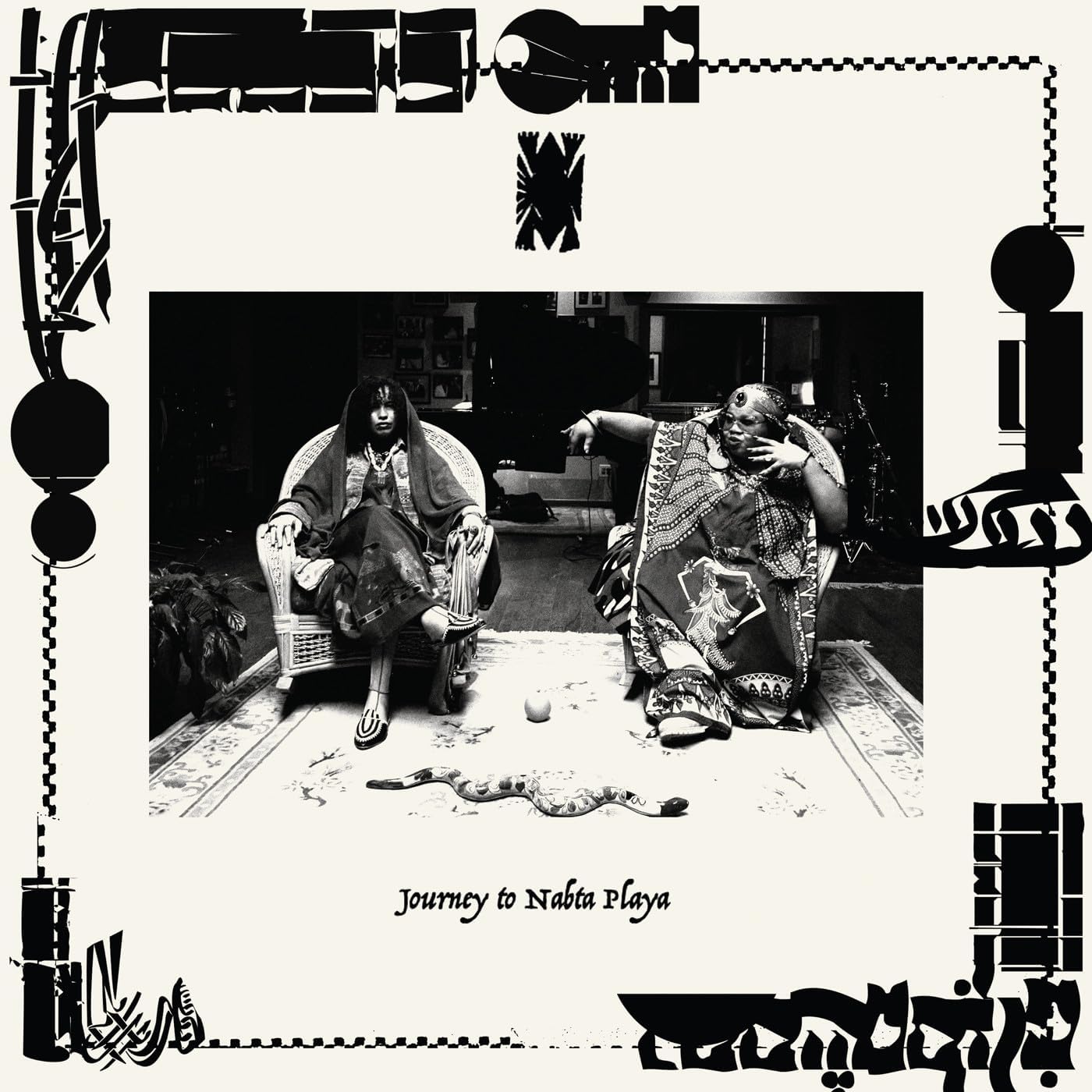 Black and white vinyl record cover featuring two people seated indoors.