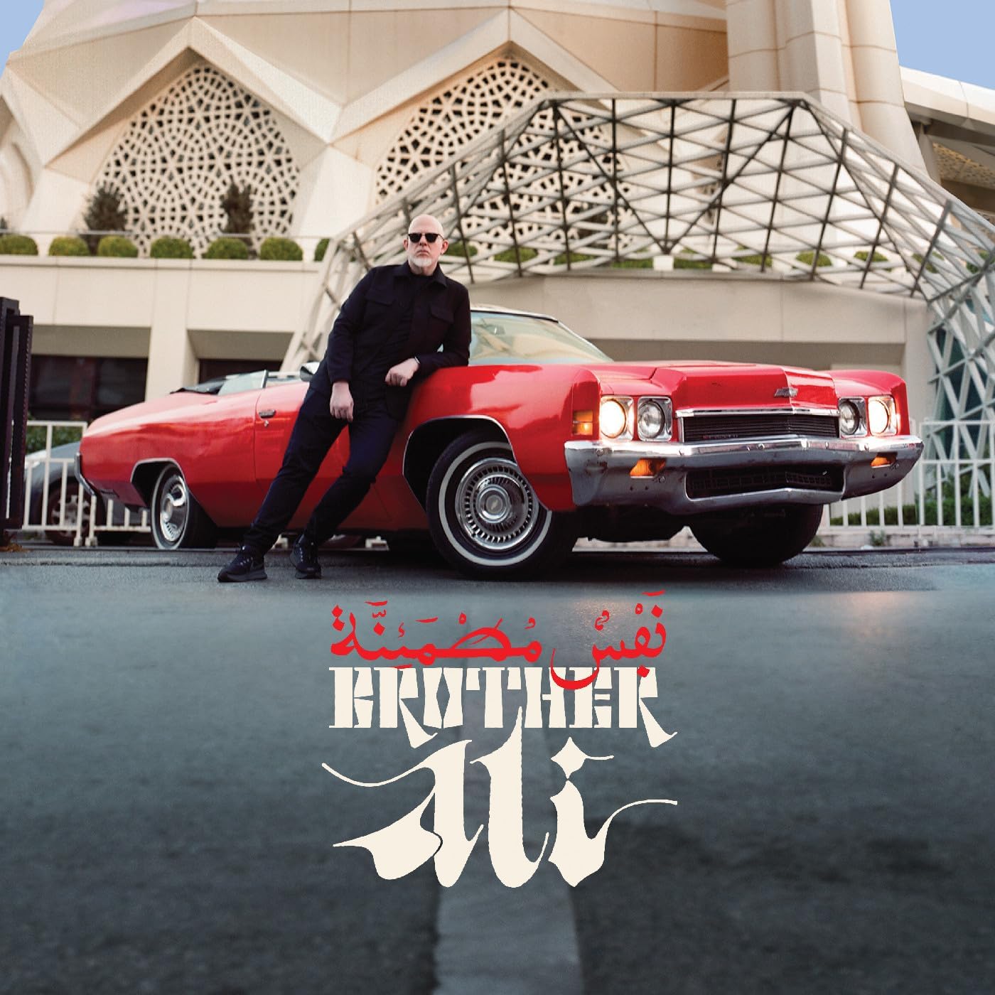 Brother Ali poses with a classic red car, album art with Arabic script.