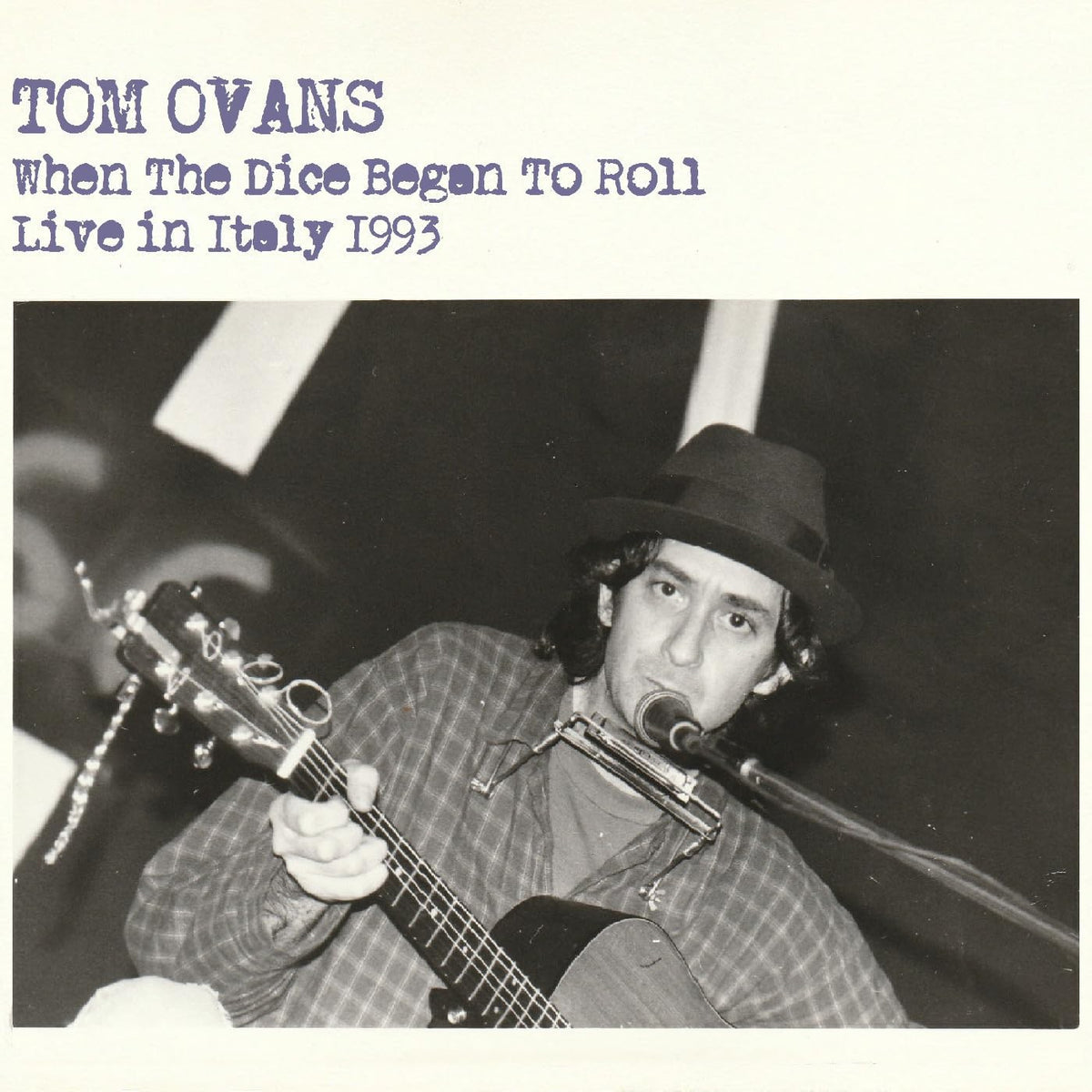Black and white CD cover featuring Tom Evans playing guitar with a harmonica.