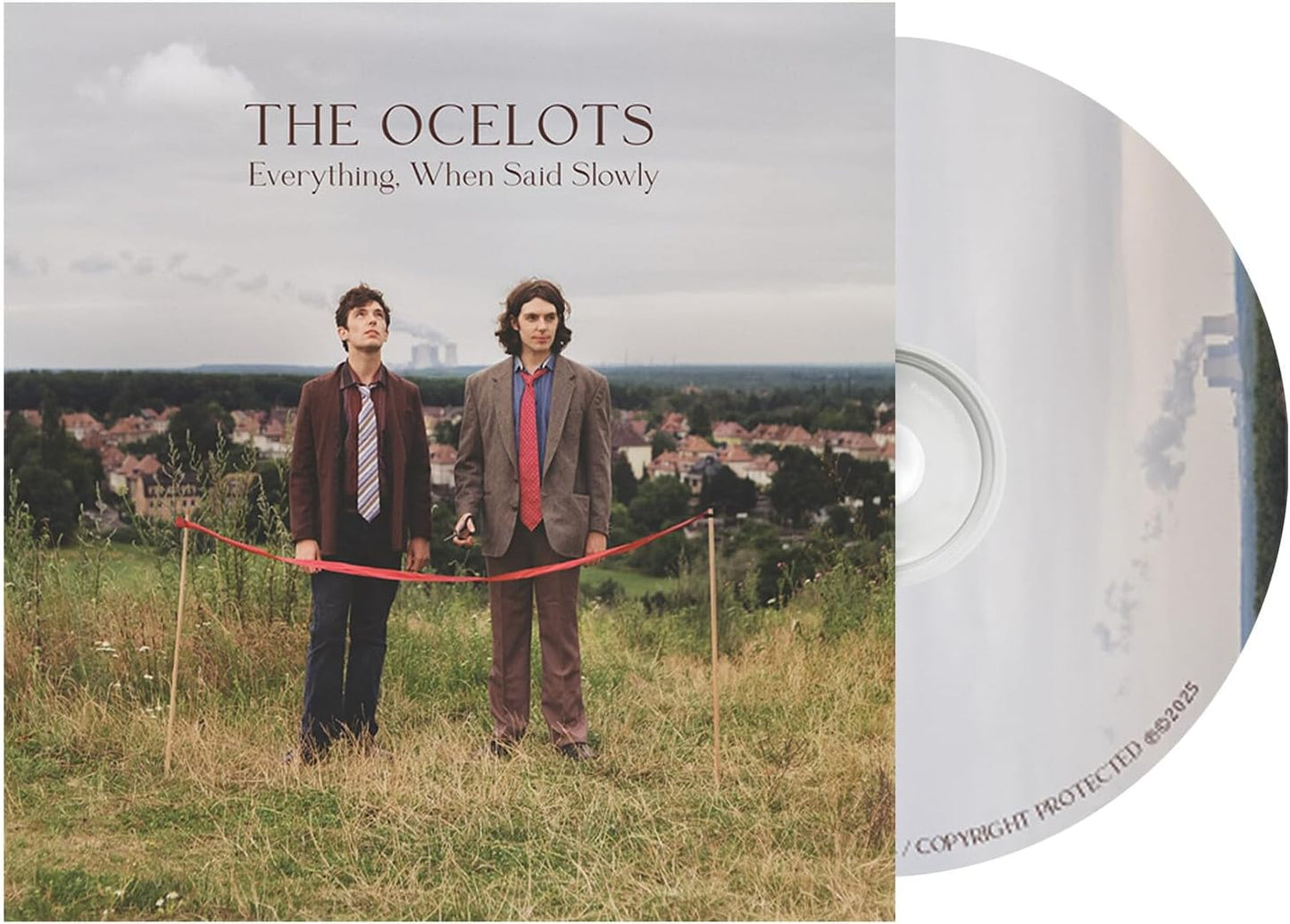 CD cover: two men with a red ribbon on a grassy hill.