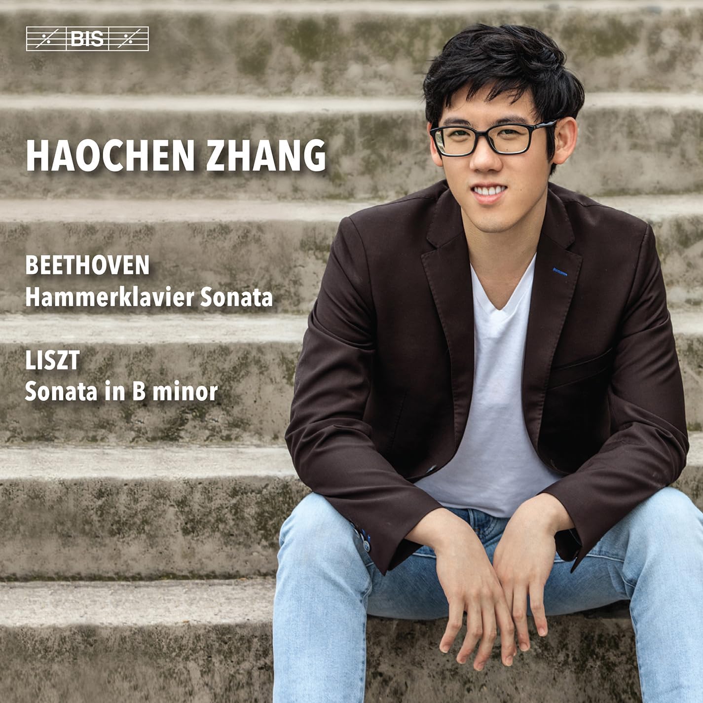 Pianist Haochen Zhang sits on steps, album cover for Beethoven & Liszt.