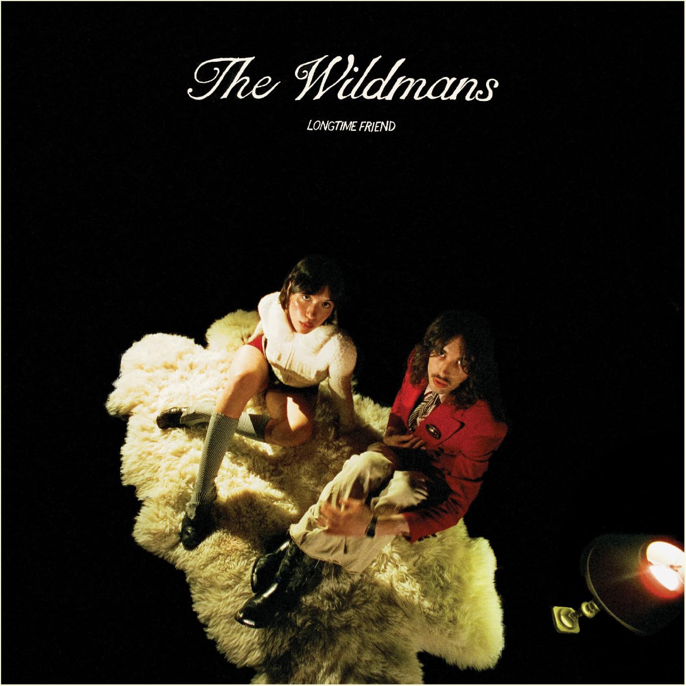 Album cover: two people on a white rug, dark background.