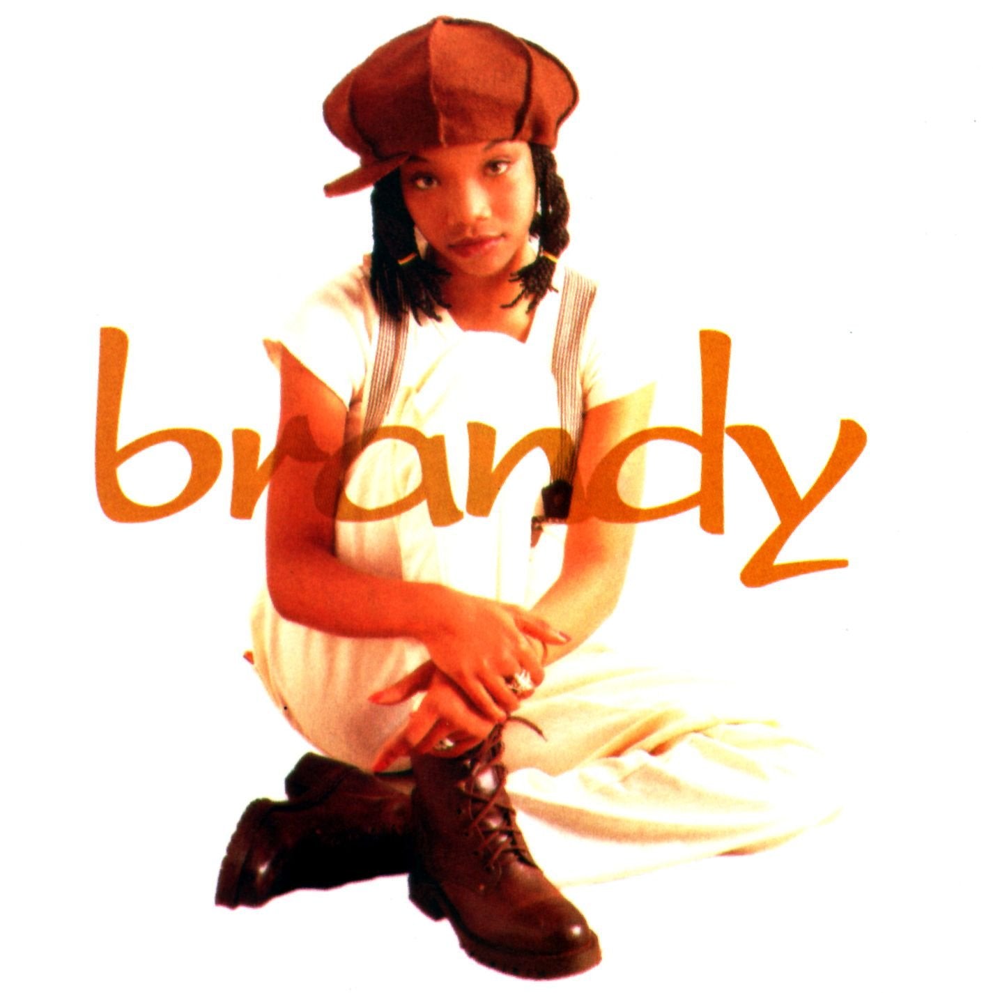 Brandy Norwood in a newsboy cap and overalls, album cover art.