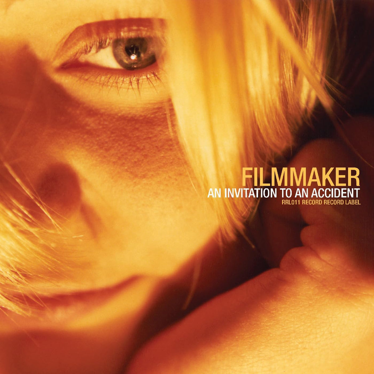 Close-up of an eye with blonde hair, album cover text "Filmmaker".