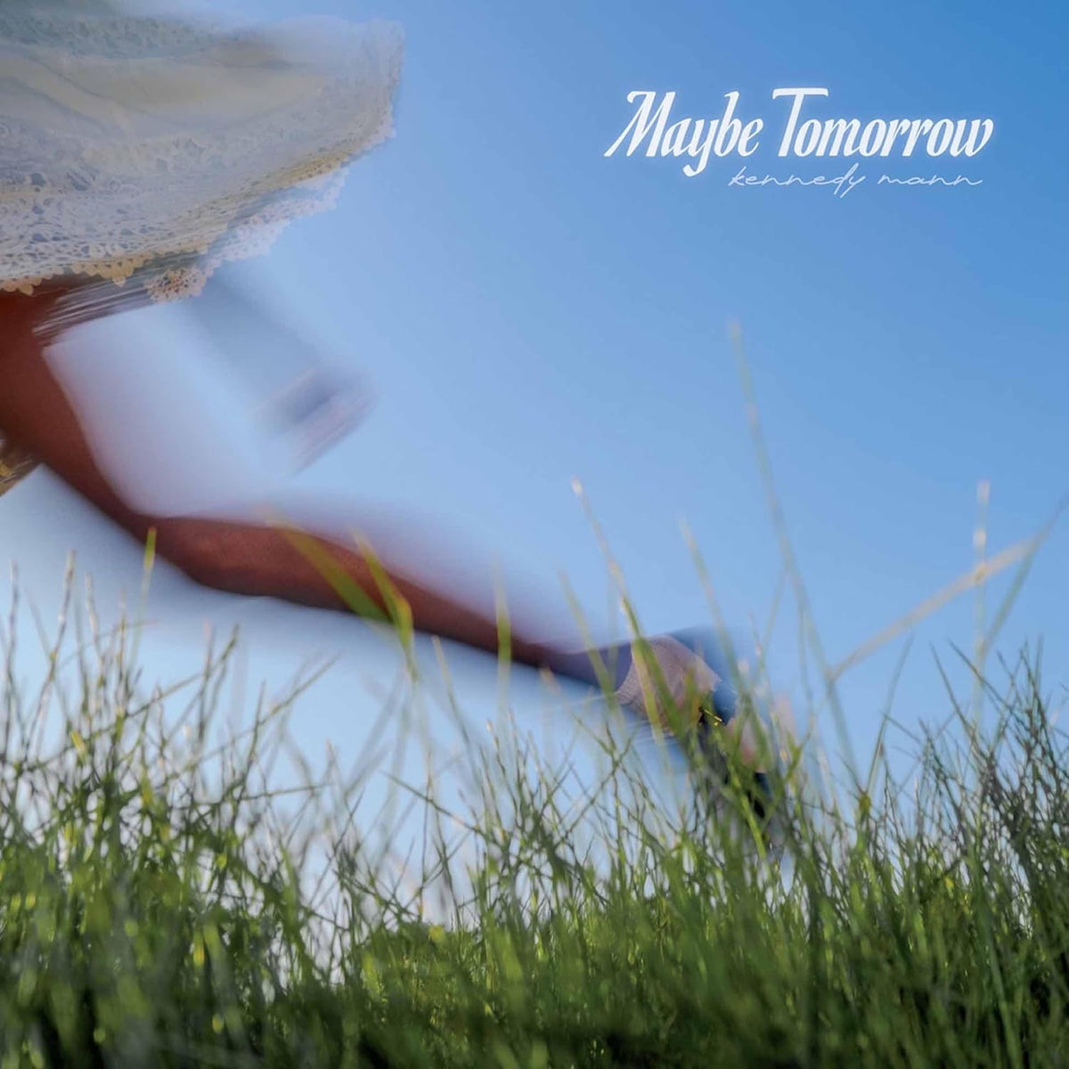 Album cover for Kennedy Mann’s “Maybe Tomorrow” featuring a blurred figure in grass.