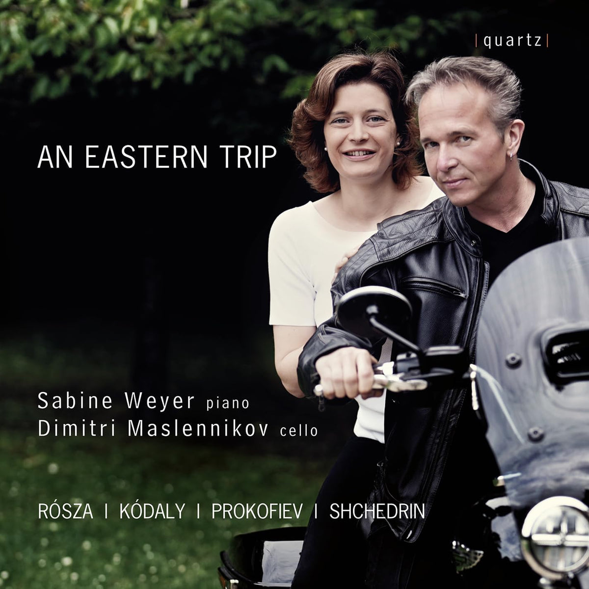 CD cover featuring a smiling woman and man with a cello and motorcycle.